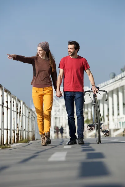 Feliz joven pareja caminando al aire libre señalando —  Fotos de Stock