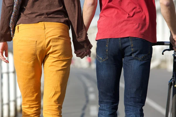Молодая пара ходит и держит за руки — стоковое фото