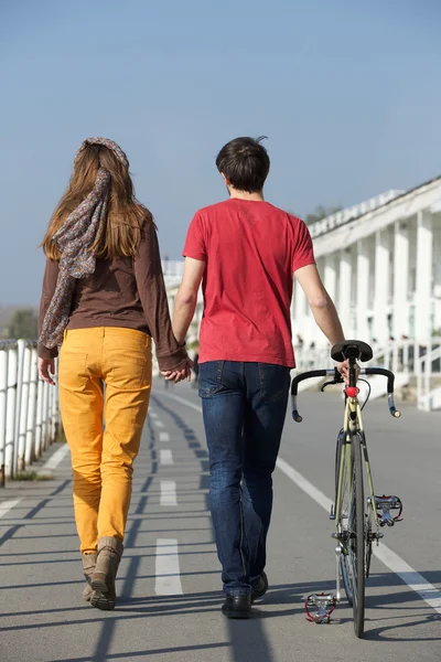 Achterzijde weergave portret van een jong koppel buiten lopen — Stockfoto