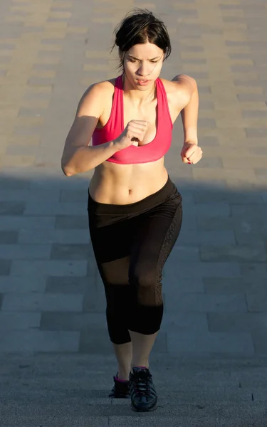 Mujer atlética joven corriendo escaleras arriba — Foto de Stock