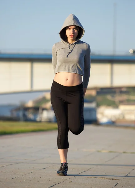 Jovem mulher alongamento músculos da perna ao ar livre — Fotografia de Stock