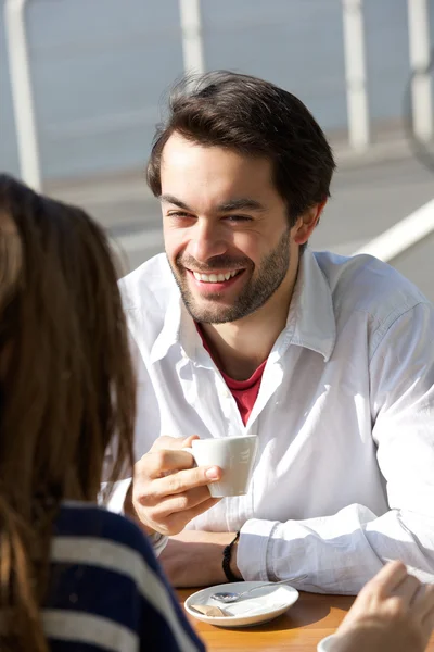 Счастливый молодой человек пьет кофе с женщиной — стоковое фото