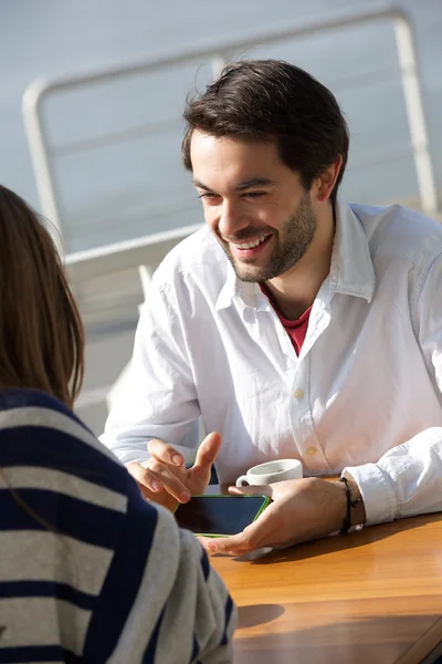 Young man smiling and showing woman mobile phone — Stock Photo, Image