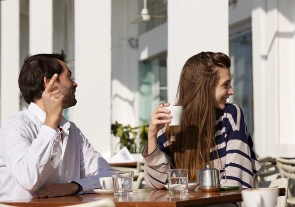 Pareja joven sentada en la cafetería al aire libre pidiendo la cuenta —  Fotos de Stock