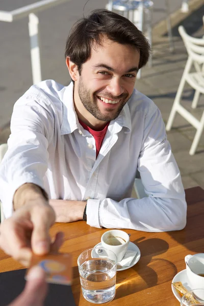 Young man giving credit card for payment at restaurant — Stock Photo, Image