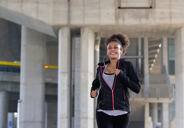 Lächelnde junge Frau beim Joggen im Freien — Stockfoto