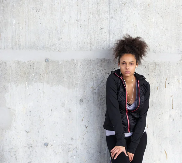 Attractive sports young woman standing with earphones — Stock Photo, Image