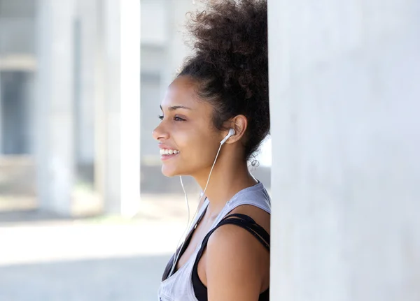 Mujer joven atractiva sonriendo con auriculares — Foto de Stock