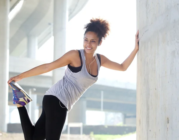 Happy young fitness woman stretching outdoors — Stock Photo, Image