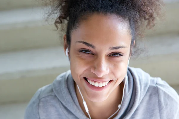 Donna sportiva afroamericana sorridente con gli auricolari — Foto Stock