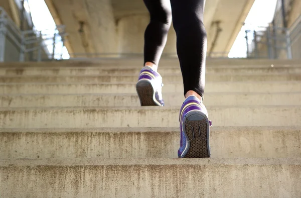 Спортивная женщина бежит вверх по лестнице — стоковое фото