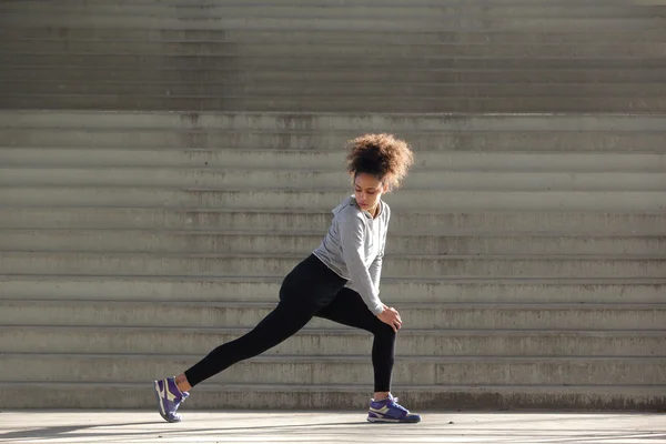 Portrait latéral d'une jeune femme étirant les muscles des jambes — Photo