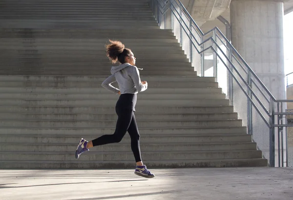 Здоровая молодая женщина, бегущая в городской среде — стоковое фото