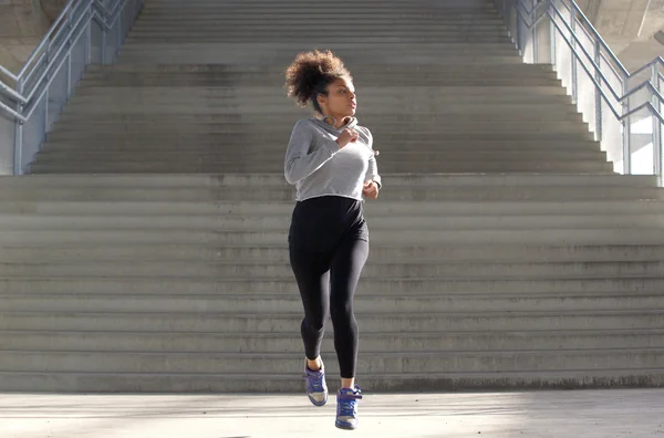 Retrato de comprimento total de uma atraente jovem mulher negra jogging — Fotografia de Stock