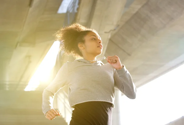 Young woman running in urban environment — Stock Photo, Image