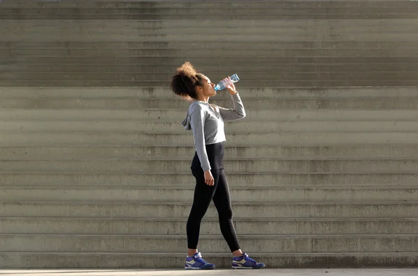 Africano americano deportes mujer bebiendo de agua botella — Foto de Stock