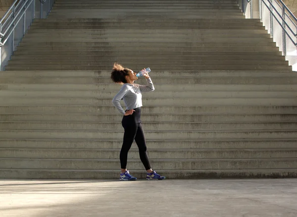 Спортивная женщина пьет воду из бутылки — стоковое фото