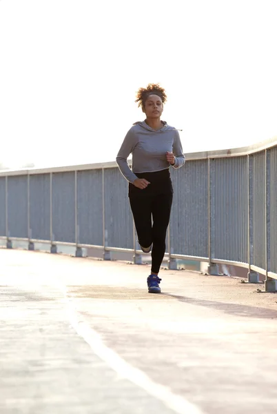 Junge Joggerin läuft ins Freie — Stockfoto