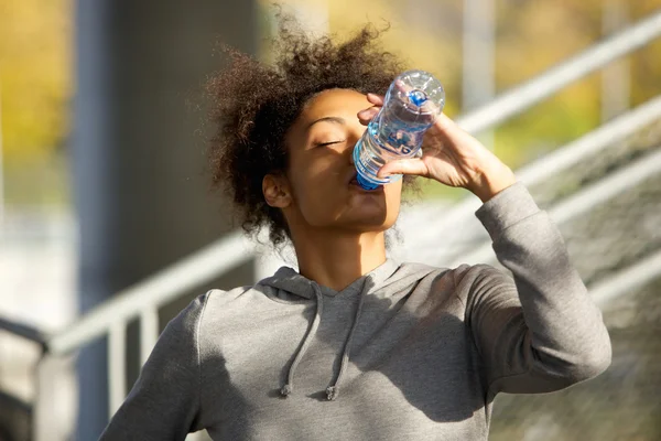 Giovane donna sportiva che beve acqua dalla bottiglia — Foto Stock