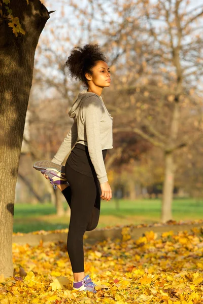 Adatto a giovani afro-americani donna stretching muscoli — Foto Stock