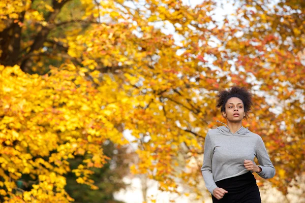 Jonge vrouw joggen buiten in het park — Stockfoto