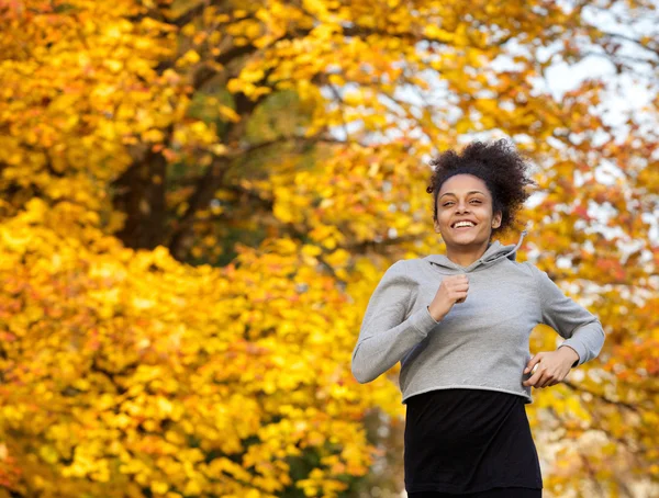 Sorridente giovane donna sportiva correre all'aperto — Foto Stock