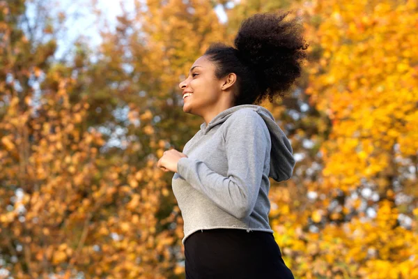 Happy young woman running outdoors — Stock Photo, Image