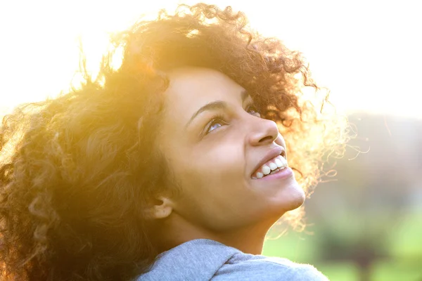 Giovane donna afroamericana sorridente e guardando in alto — Foto Stock