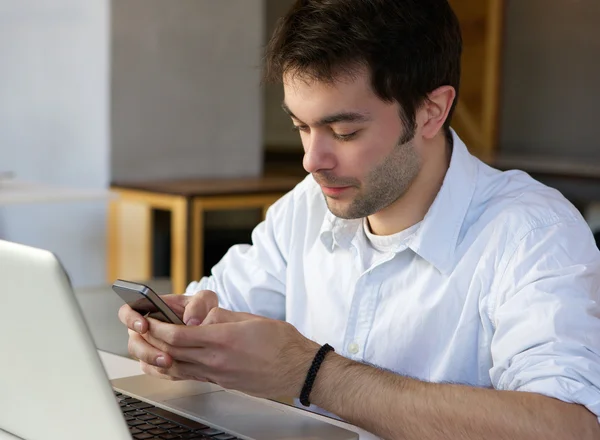 Junger Mann verschickt SMS auf Handy — Stockfoto