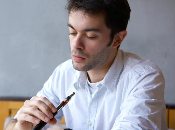 Young man smoking electric cigarette — Stock Photo, Image