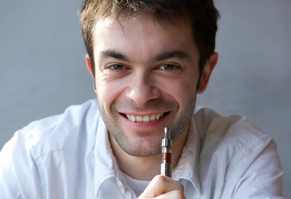 Young man smiling with e cigarette in hand — Stock Photo, Image