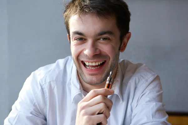 Jovem feliz segurando cigarro elétrico — Fotografia de Stock