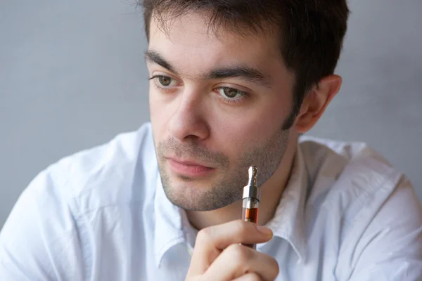 Junger Mann raucht Dampfzigarette — Stockfoto