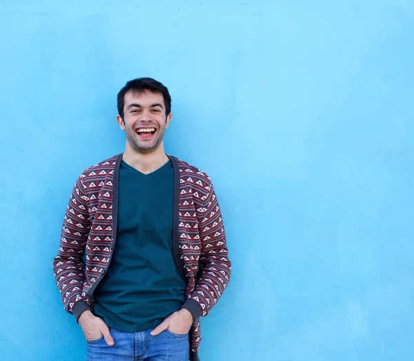 Jovem rindo contra fundo azul — Fotografia de Stock