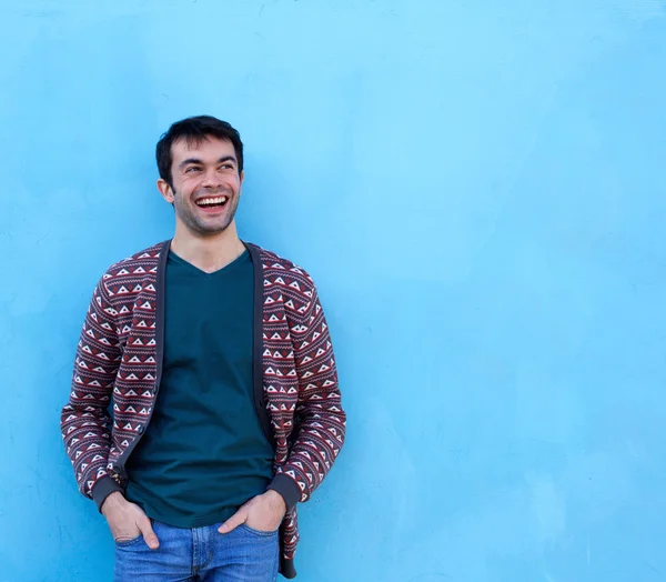 Joven confiado sonriendo sobre fondo azul — Foto de Stock