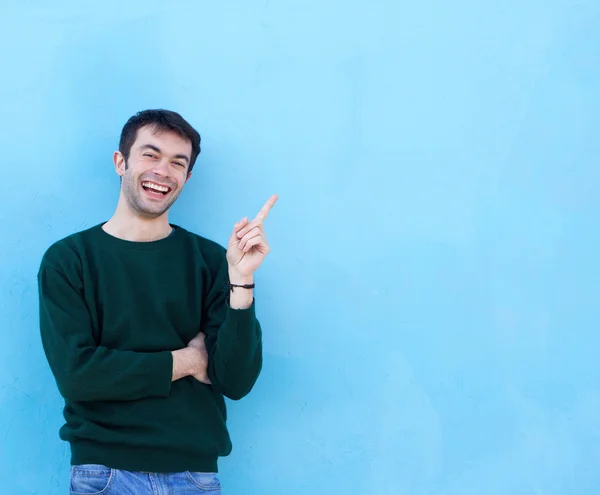 Jovem feliz sorrindo e apontando o dedo — Fotografia de Stock