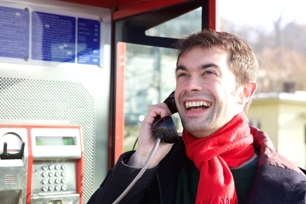 Junger Mann telefoniert aus Telefonzelle — Stockfoto