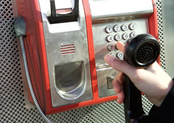 Hand pushing buttons at public phone — Stock Photo, Image