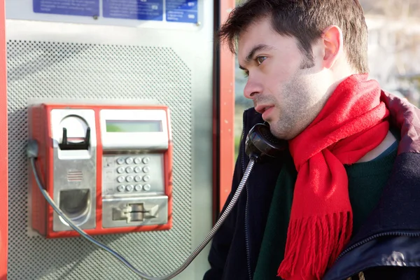 Junger Mann telefoniert aus öffentlichem Telefon — Stockfoto