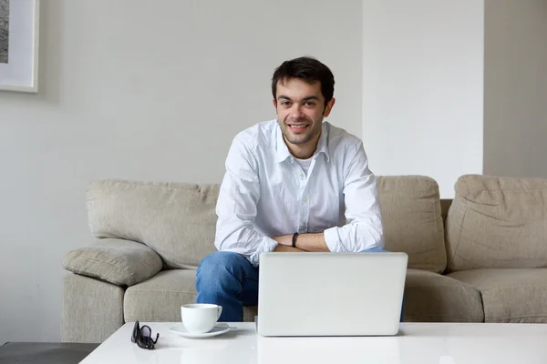 Young man relaxing at home with laptop — Stock Photo, Image