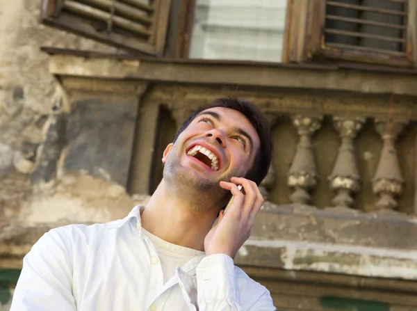 Genç adam açık havada hareket eden telefon ile gülüyor — Stok fotoğraf