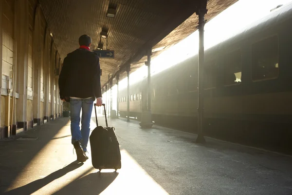 Člověk na cestách s taškou na vlakovém nádraží — Stock fotografie