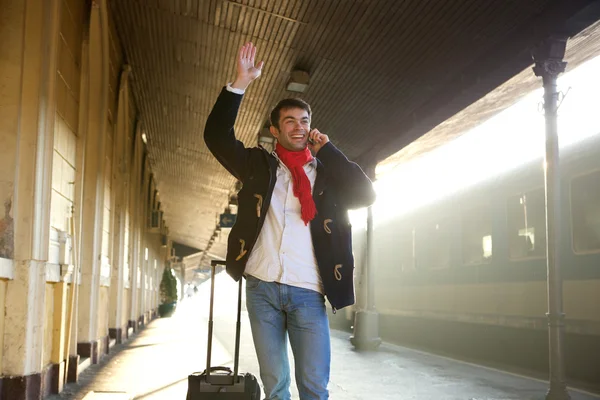 Jovem acenando a mão na estação de trem — Fotografia de Stock