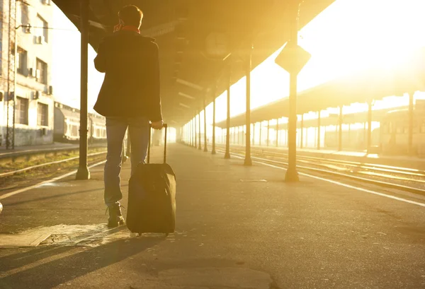 Άτομο που στέκεται με τσάντα και κινητό τηλέφωνο στον σταθμό τρένου — Φωτογραφία Αρχείου