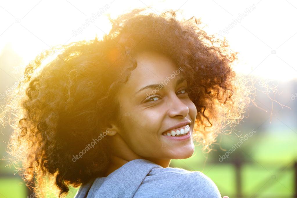 Cheerful young african american woman smiling outdoors