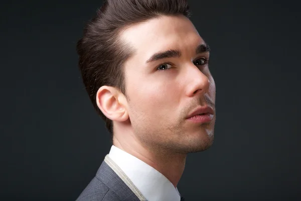 Handsome young man posing on gray background — Stock Photo, Image