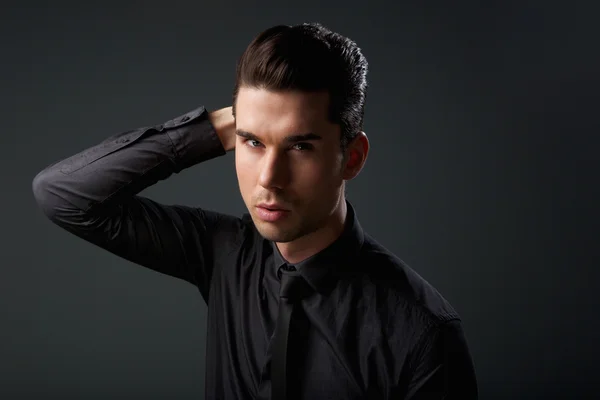 Portrait of a stylish young man with hand in hair Stock Image