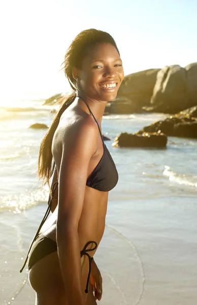 Mujer afroamericana en bikini sonriendo en la playa —  Fotos de Stock