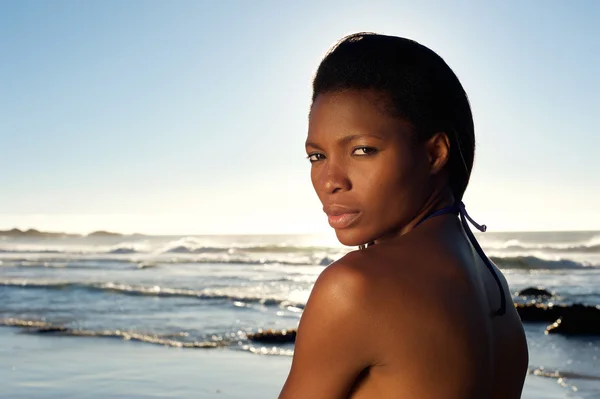 Mooie jonge zwarte vrouw die zich voordeed op het strand — Stockfoto