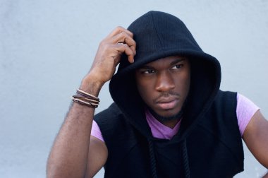 Yakışıklı genç adam açık havada oturma ile kapüşonlu sweatshirt